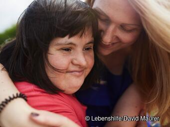 Zwei Frauen umarmen sich.